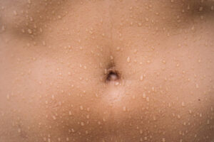 zoom sur un ventre avec des gouttes d'eau - endobelly